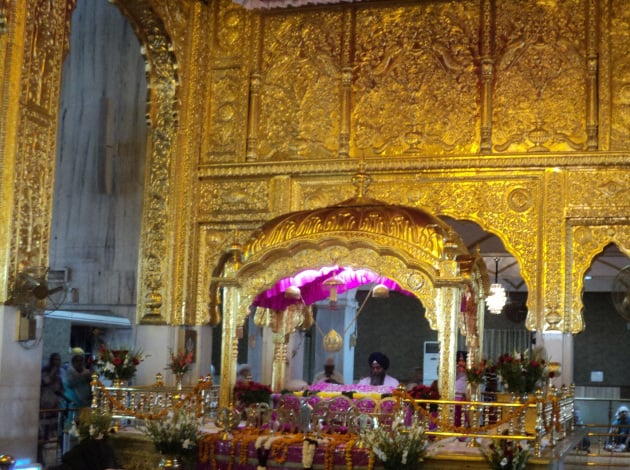 At the centre of the gilded shrine, the Granthi reads the Sikh scripture