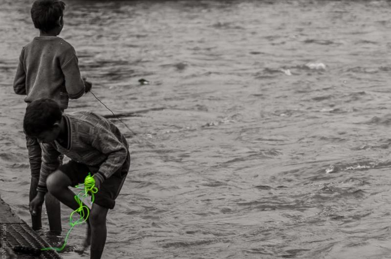 Children at Har ki Pauri searching for coins