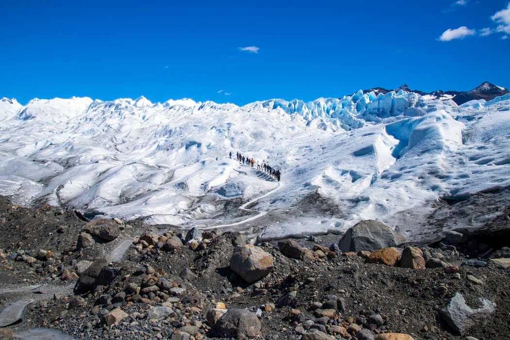 Group of trekkers climbing up on the snow trail