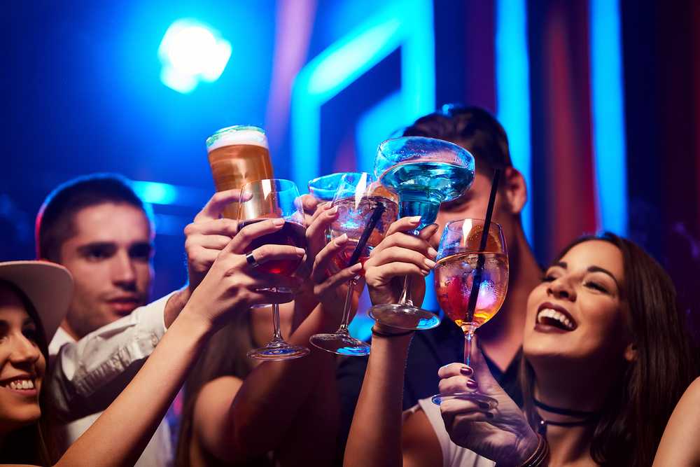 People toasting their drinks in a bar
