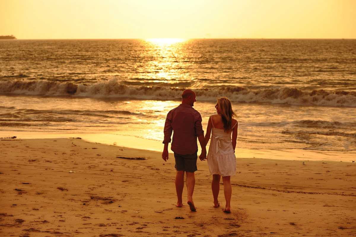 Couple walking on a beach during sunset